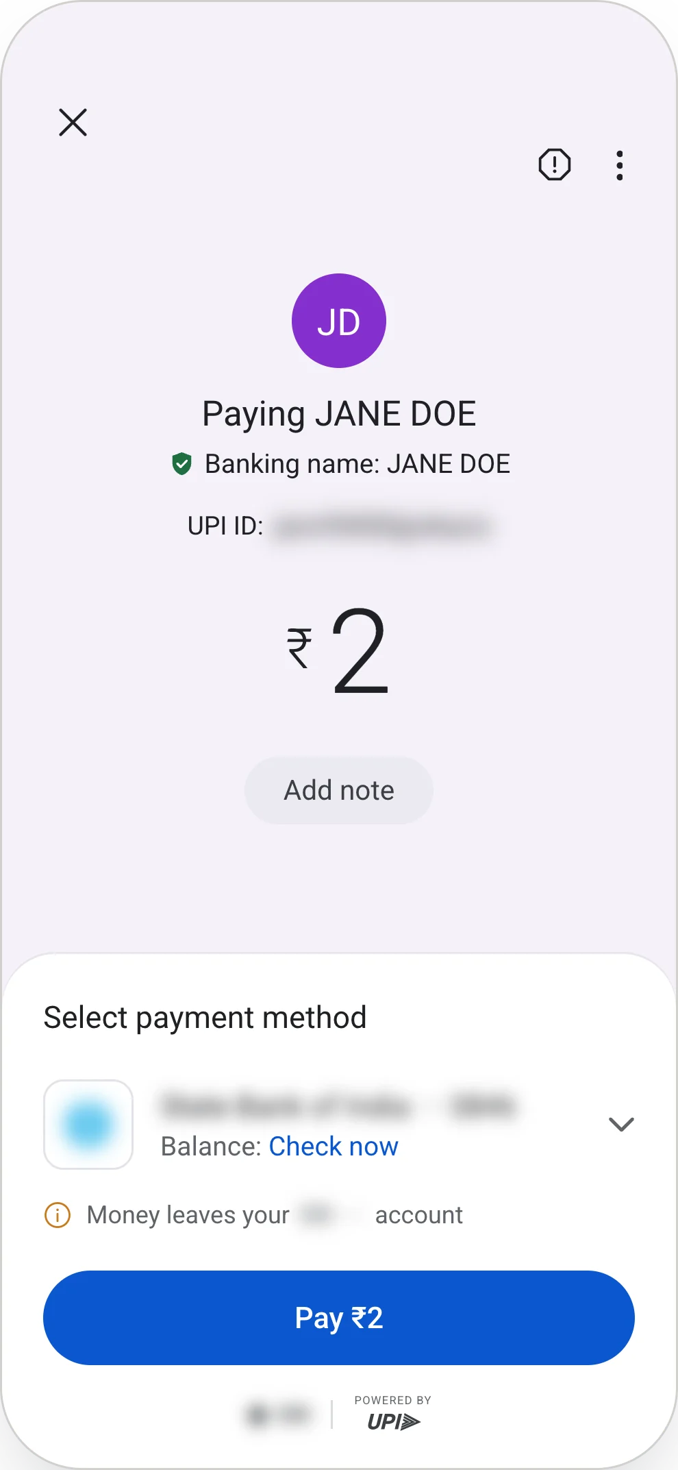 Option 2, proposed. The Google Pay payment panel with a line added beneath the bank row: an amber information icon and the words "Money leaves your SBI ••••2449 account", with the bank name and masked digits blurred. Above the panel sit "Paying JANE DOE", the verified banking name, a blurred UPI ID and the amount at ₹2. The panel is headed "Select payment method" and holds the blurred bank row with a balance link, the added line, and a blue "Pay ₹2" button.